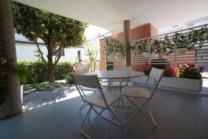 una mesa blanca y sillas en un patio en B&B Villino Giovanna, en Porto SantʼElpidio