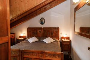 een slaapkamer met een houten bed met 2 nachtkastjes bij Casa montagna CIELO BLU in Oulx
