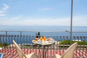- une table avec de la nourriture sur un balcon donnant sur l'océan dans l'établissement Locanda Costa D'Amalfi, à Amalfi