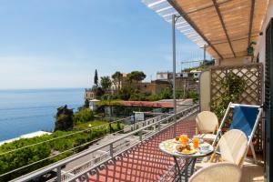balcón con mesa y vistas al océano en Locanda Costa D'Amalfi, en Amalfi