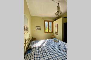 een slaapkamer met een bed met een geruite deken bij Barchessa Ca’ Leon sul naviglio del Brenta in Mira