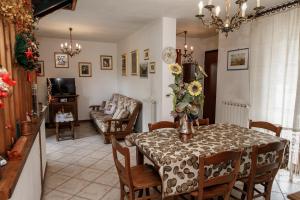 a dining room with a table with a vase of flowers at Cielo Blu Casa Alpina Vialattea in Oulx
