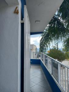 a door to a balcony with a view of the beach at Apartamento avenida 04 com ar condicionado in São Thomé das Letras