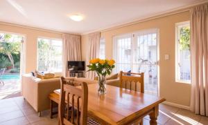 a living room with a table with a vase of flowers on it at Squirrel's End in Cape Town