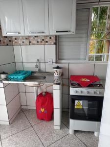 a small kitchen with a stove and a sink at Apartamento avenida 04 com ar condicionado in São Thomé das Letras +7 photos