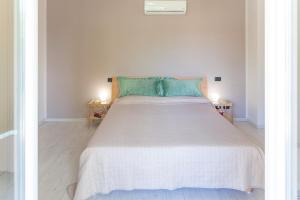 1 dormitorio con 1 cama blanca grande con almohadas verdes en Appartamento Alice - Cervo, en Cervo