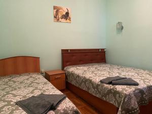1 dormitorio con 2 camas y una foto en la pared en Guest House VIP, en Osh