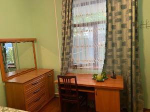 a bedroom with a desk and a window with a mirror at Guest House VIP in Osh