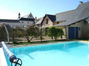 - une piscine en face d'une maison dans l'établissement Gites Aubelle - La Maison Aubelle, à Montreuil-Bellay