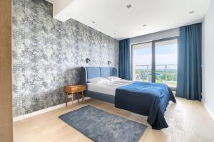 sypialnia z niebieskim łóżkiem i betonową ścianą w obiekcie Natural Apartamenty w Darłówku