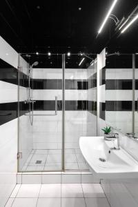 リヴィウにあるLEOGRAND Apartments on Udatnogo 4-2の白いバスルーム(シャワー、シンク付)