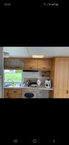 a kitchen with wooden cabinets and a stove top oven at Herzfennerhof Mobilheim in Auw