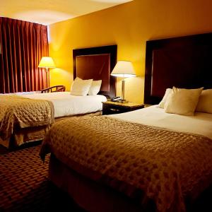 two beds in a hotel room with yellow walls at Town Inn in Bordentown