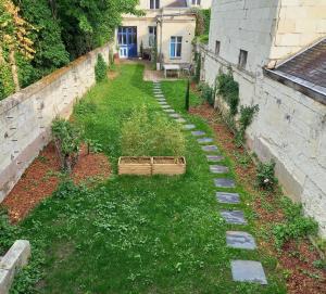 einen leeren Hinterhof mit einem Garten mit Pflanzen und einem Zaun in der Unterkunft HISTOIRE DE LOIRE - La Maison in Saumur