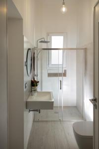 bagno bianco con lavandino e doccia di east coast house a Poggiardo