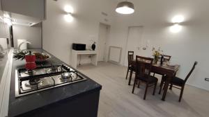 a kitchen and dining room with a stove and a table at east coast house in Poggiardo
