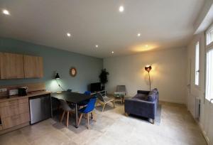 a kitchen and living room with a couch and a table at HISTOIRE DE LOIRE - La Maison in Saumur +17 photos