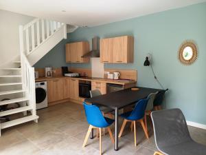 a kitchen with a black table and blue chairs at HISTOIRE DE LOIRE - La Maison in Saumur +17 photos