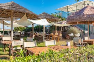 un restaurante con mesas, sillas y sombrillas en Case vacanze Blue Bay Resort en Roseto degli Abruzzi