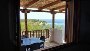 una mesa y sillas en un balcón con vistas al océano en Aliki House, en Alyki
