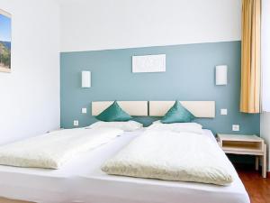 um quarto com uma grande cama branca e uma parede azul em Ahrtal Apartments em Bad Neuenahr-Ahrweiler