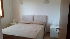a small bedroom with a bed and two night stands at Aliki House in Alyki