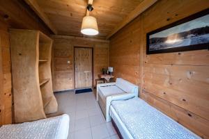 uma sala de estar com um sofá e uma televisão numa cabina em Zagroda Chryszczata em Smolnik