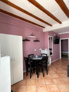 a dining room with a table and chairs and purple walls at Apartment ILI in Piran