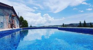 a large blue swimming pool next to a building at Cosmema House 1 Hot tub and swimming pool villa in Stroumbi