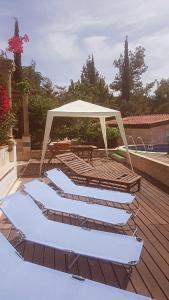 a deck with a gazebo and chairs and a table at Cosmema House 1 Hot tub and swimming pool villa in Stroumbi