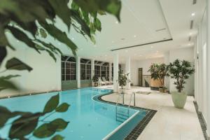 an indoor pool in a house with blue water at Hotel Hirschen in Silbertal