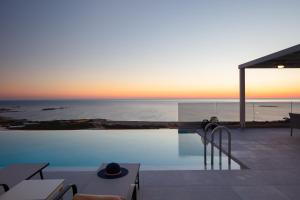 una piscina con vistas al océano al atardecer en Falasarna village en Falasarna