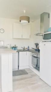 a kitchen with white cabinets and a white refrigerator at La Longère à la Mer 6 pers 3 chambres grand jardin clôt a Fort-Mahon-Plage in Fort-Mahon-Plage