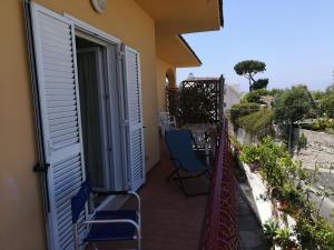 un balcone con sedie e una porta aperta di Appartamenti La Balestra a Ischia