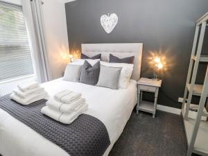 um quarto com uma grande cama branca com toalhas em Victoria House em Holmfirth