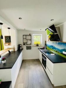 a kitchen with white cabinets and a fishtank on the counter at BÄRENALP Ferienwohnen in Garmisch-Partenkirchen