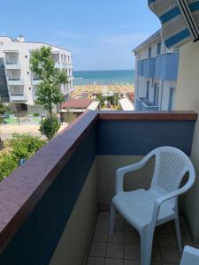 einen weißen Stuhl auf einem Balkon mit Meerblick in der Unterkunft Hotel Del Vecchio in Rimini