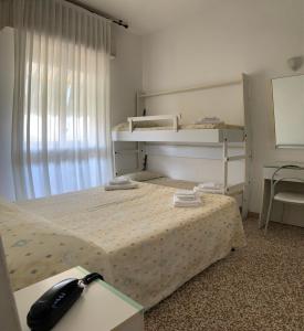 una camera da letto con un letto e un telefono sopra di Hotel Del Vecchio a Rimini