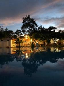 una piscina de agua por la noche con un edificio y árboles en Don Kişot Olimpos Hotel, en Olympos