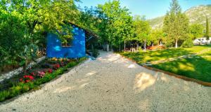 un edificio blu con fiori in un giardino di Don Kişot Olimpos Hotel a Olympos