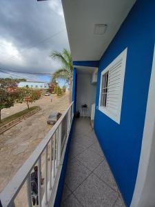 a balcony with a blue wall and a view of the beach at Apartamento avenida 07 in São Thomé das Letras