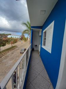 a balcony with a blue wall and a view of the beach at Apartamento avenida 07 com ar condicionado in São Thomé das Letras