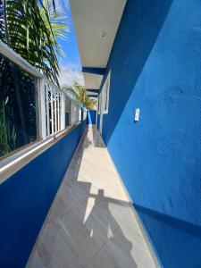 a blue house with a blue wall and a window at Apartamento avenida 07 in São Thomé das Letras