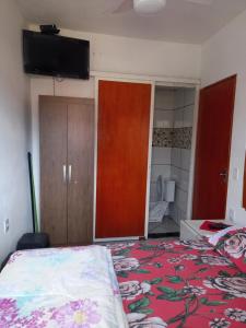a bedroom with a bed and a tv on the wall at Apartamento avenida 07 in São Thomé das Letras