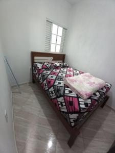 una camera con un letto con una trapunta sopra di Apartamento avenida 07 a São Thomé das Letras