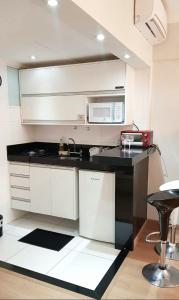 cocina con fregadero y microondas en Flat Centro Campinas - L'Hirondelle 125, en Campinas