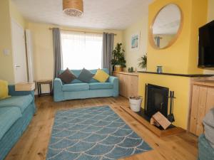 a living room with a blue couch and a fireplace at Estuary View in Newquay