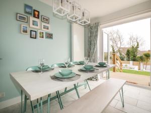 a dining room with a white table and a large window at Estuary View in Newquay