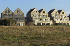 a large house on top of a grassy field at La Naturelle Duplex 90 in Wimereux