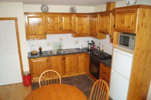 a kitchen with wooden cabinets and a wooden table at Apartment No. 3 Bunbeg in Bunbeg